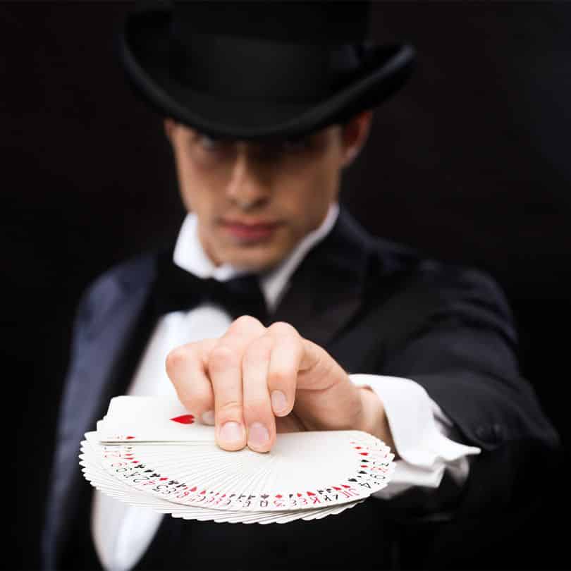 Un magicien brasse des carte comme dans Kooza